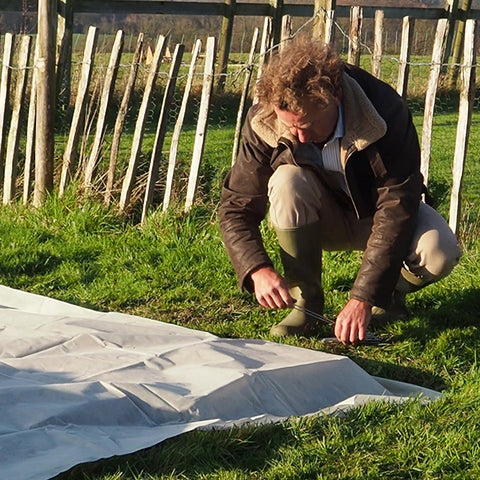 Laying our Fleece blanket garden fleece to warm soil and extend gardening season