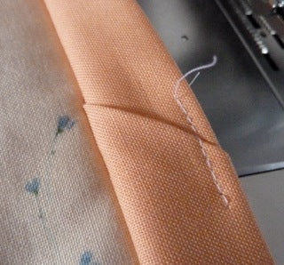 tack ends of binding to hold point in place