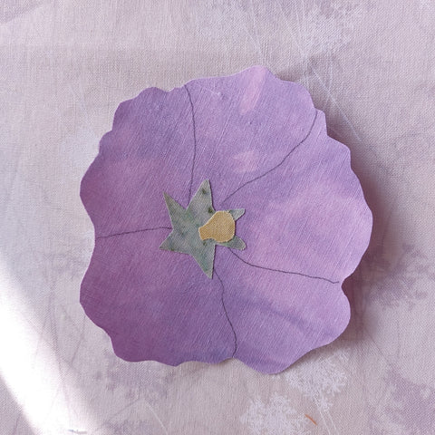 sections of hollyhock flower are pressed together before it is added to background