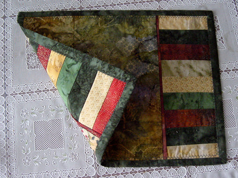 Reversible placemat showing Fall colors uppermost and Christmas theme underneath