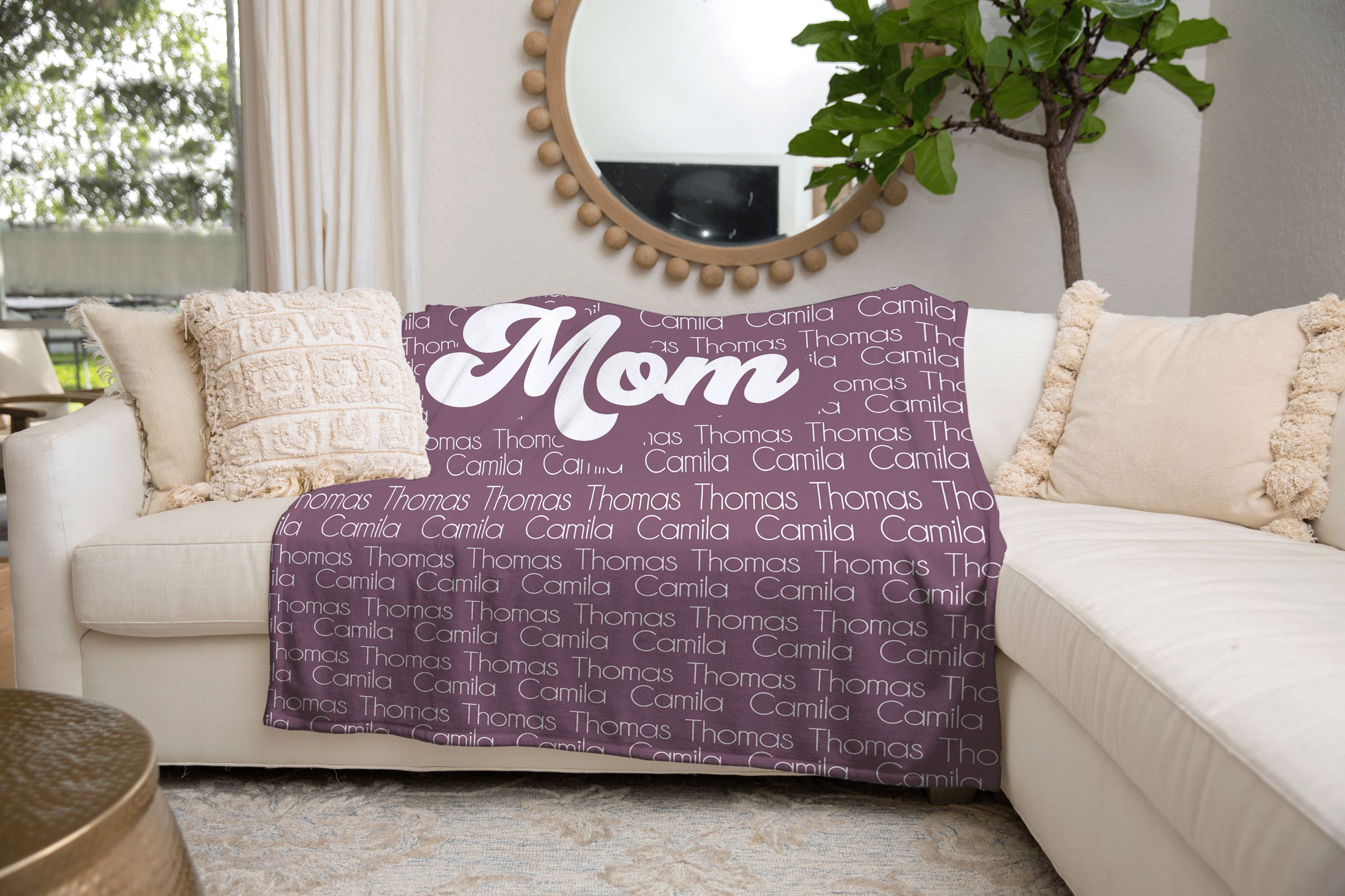 purple customizable name blanket that reads "mom" hanging on a couch