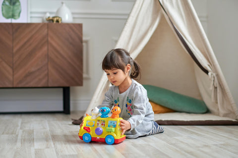 child playing with car toy - play development