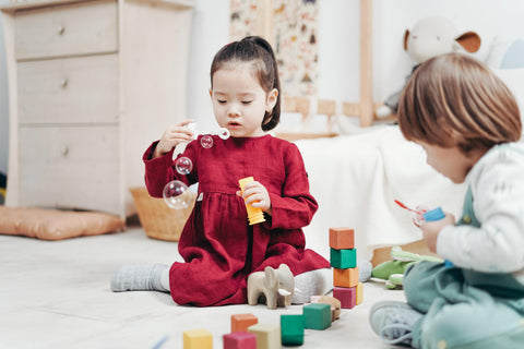 two children playing with building blocks - play development