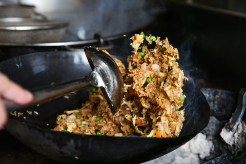 Tossing egg fried rice in a large wok