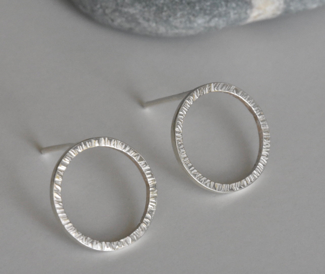 Handmade Eco Silver Textured Circle studs pictured at a slight angle without butterfly backs on.