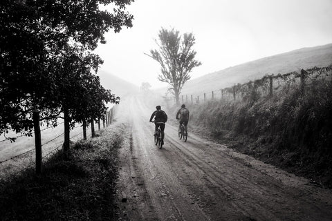 Two people riding bikes on a country trail