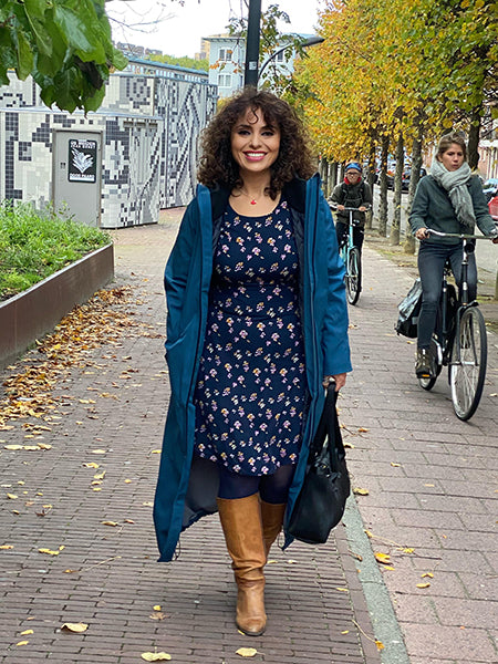 wearing blue long raincoat, SPIRIT BYBROWN on the streets of Amsterdam.Coat is waterproof and breathable