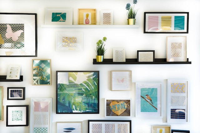 Wall with framed photos and pictures on it as an example of how custom wall art can ease the transition of moving homes