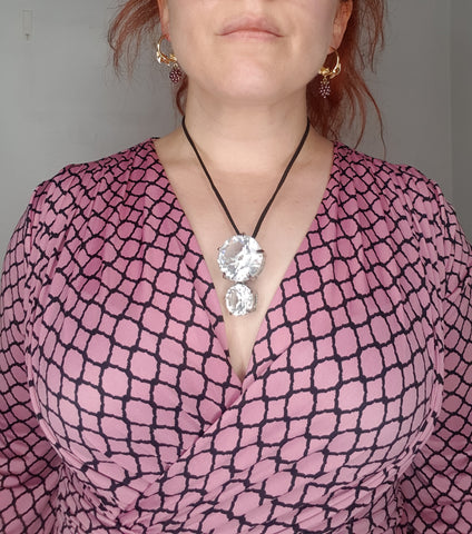 woman in a v neck dress with a dramatic pendant necklace