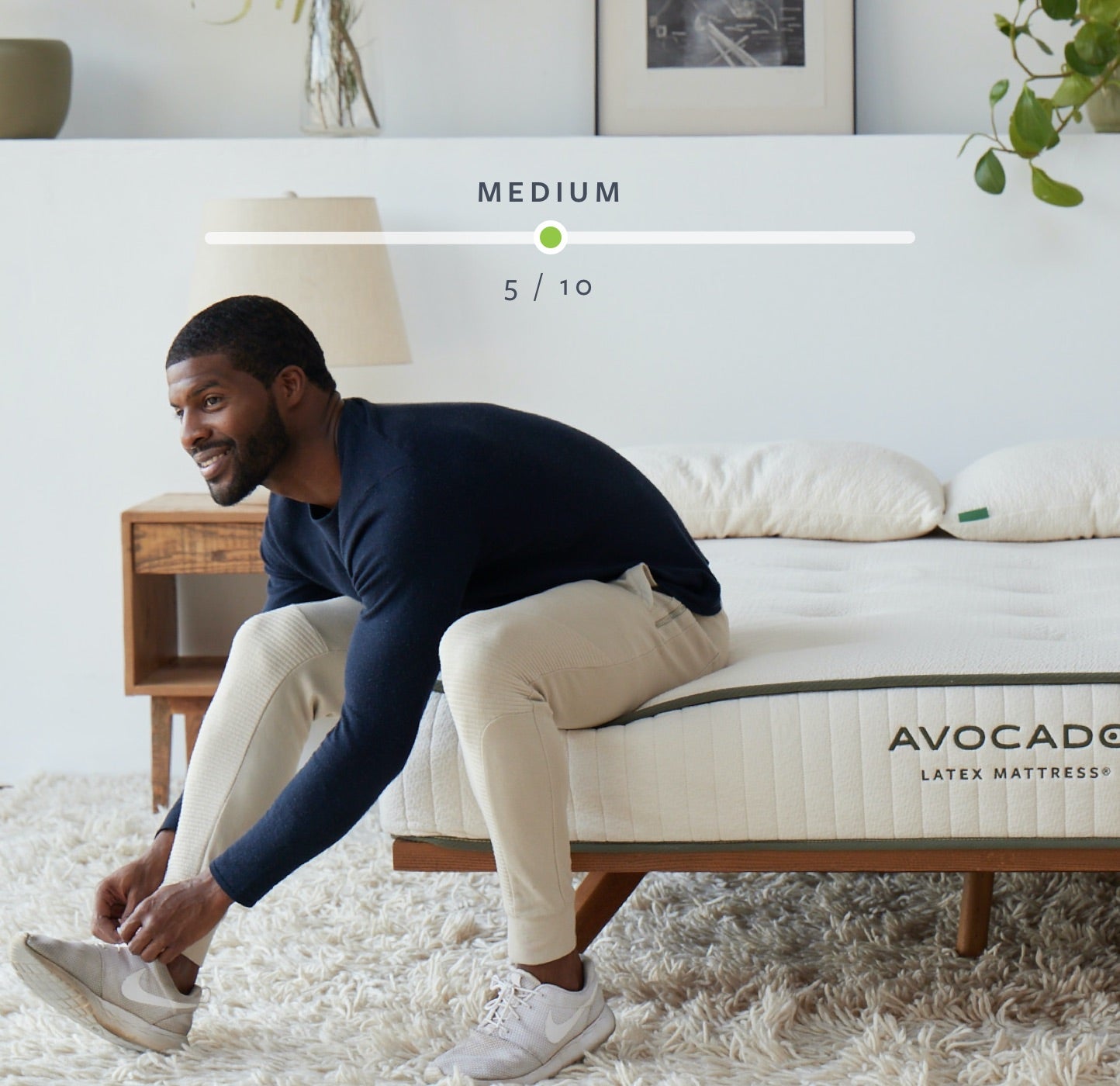 Man tying shoes while sitting on mattress