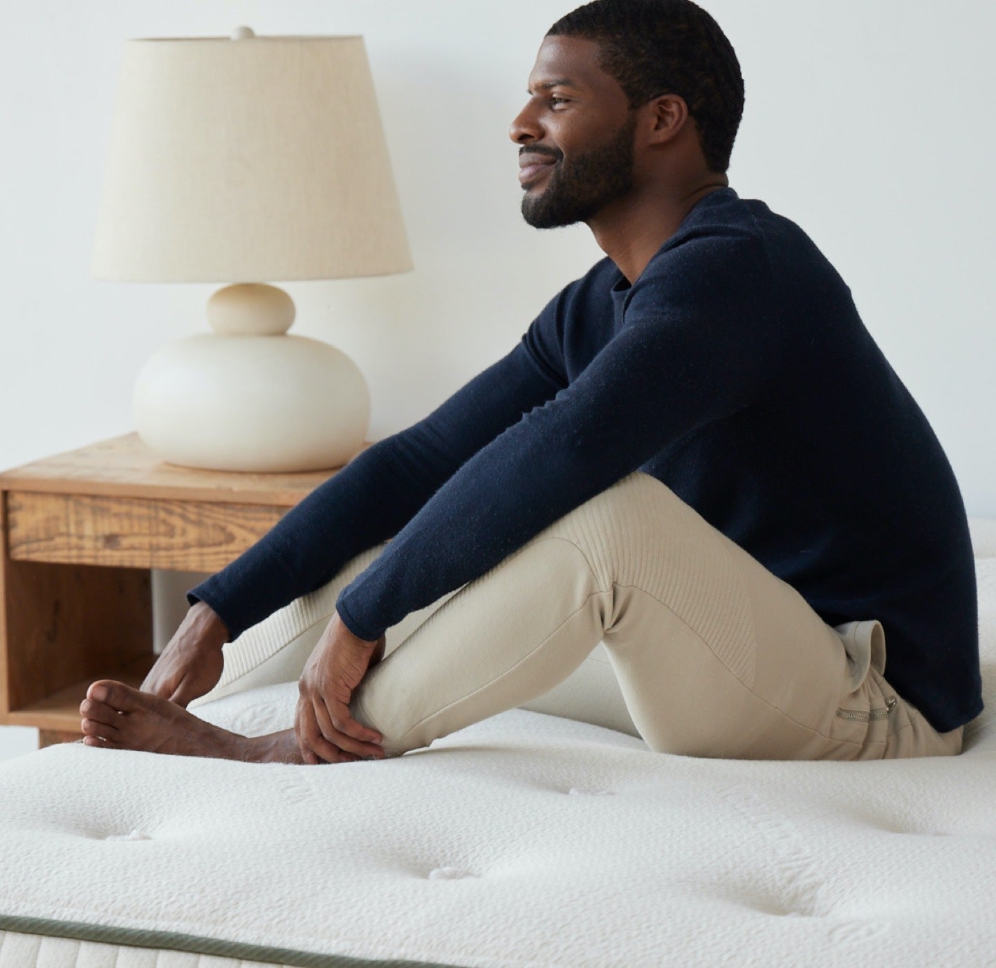 Man contently sitting on Avocado Mattress