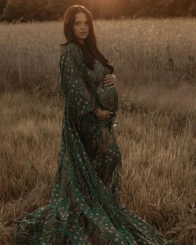 Pregnant lady wearing an emerald green sequin dress maternity dress in outdoor photoshoot