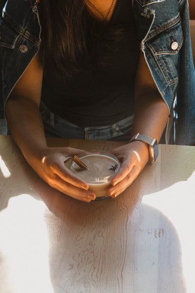 Hands holding bourbon chai cocktail