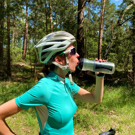 A female cyclist refuelling using a Squeeasy bottle