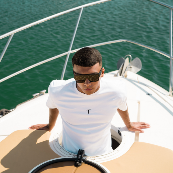 A man on a boat wearing a Tropez Official t-shirt 