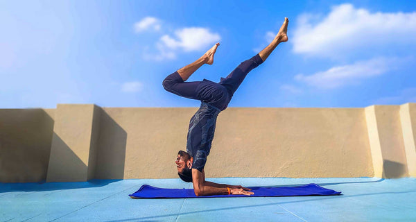A man doing Yoga infront of blue sky using Total Wellness Market Place products