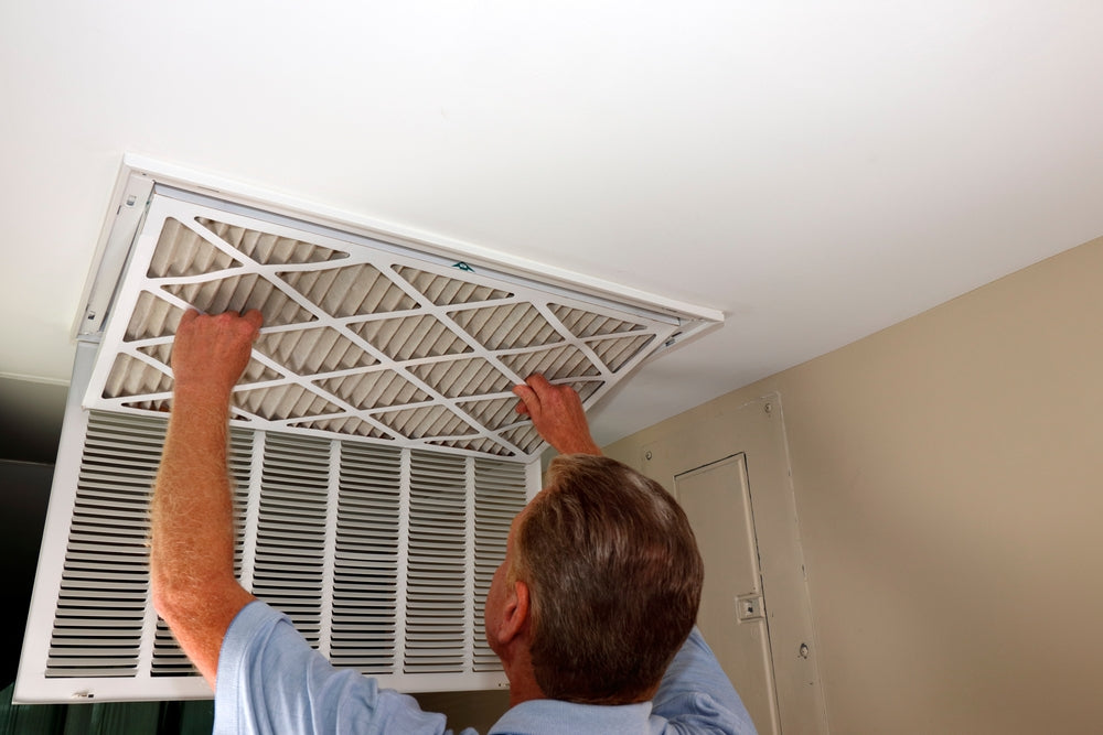 a person changing hvac home filter in his home