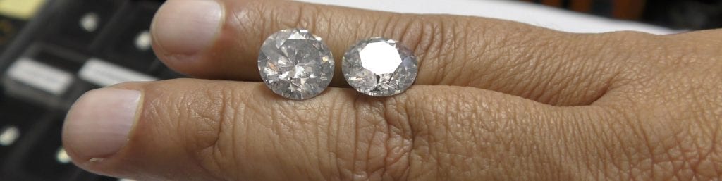 two loose diamonds on fingers