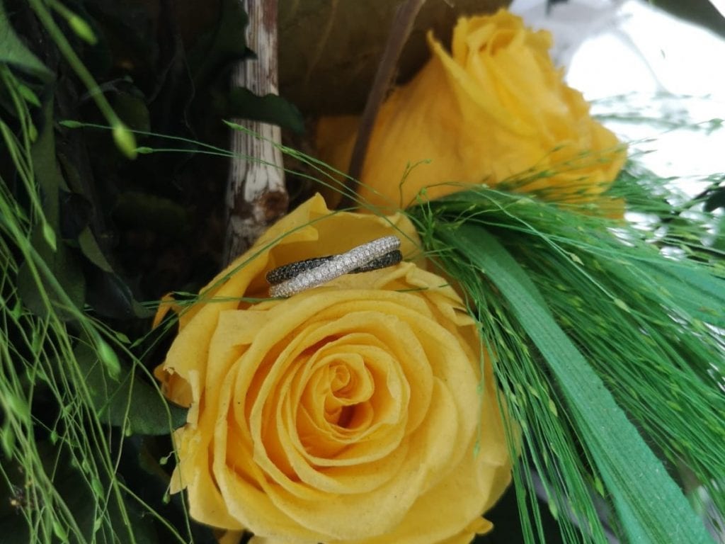 black and white wedding ring on yellow rose