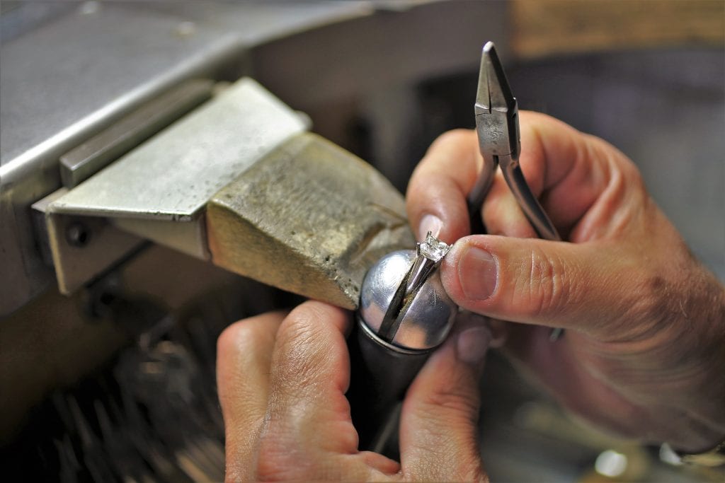 goldsmith finishing a diamond ring