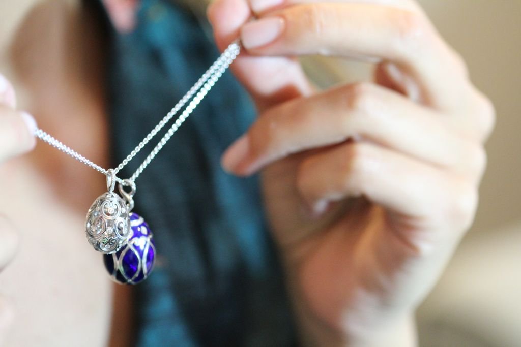 woman holding two egg pendants from faberge