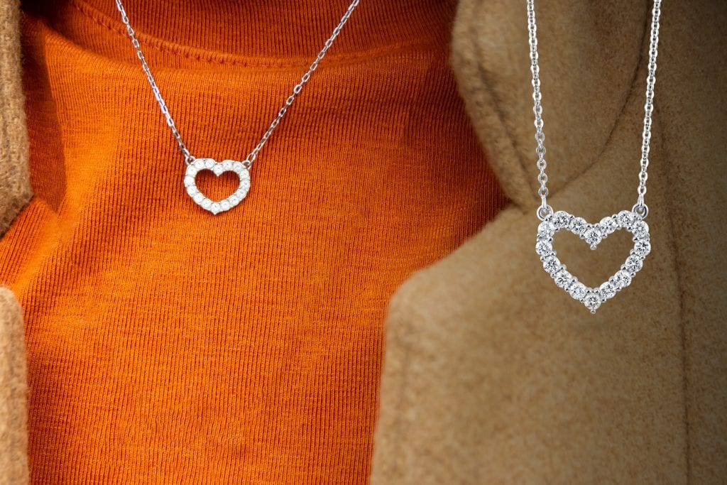 heart shaped diamond necklace on orange sweater