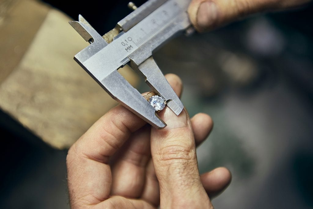 man measuring diamond mm to carat