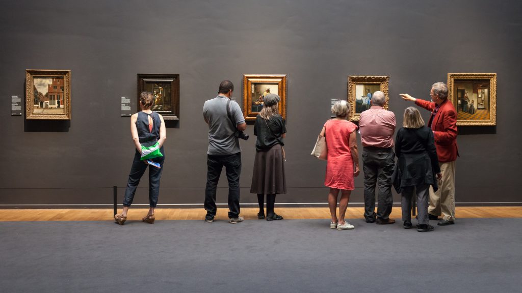 people looking at paintings at the rijksmuseum