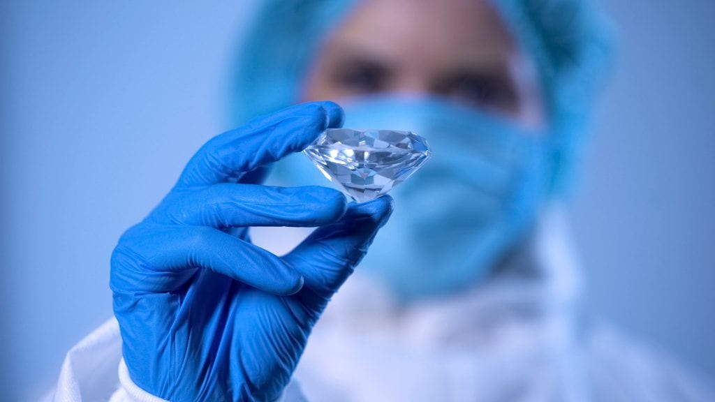 man in lab holding a big brilliant cut diamond