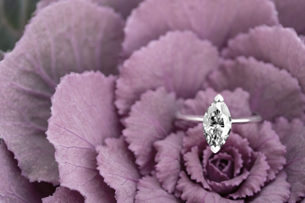 marquise cut solitaire diamond ring on purple flower