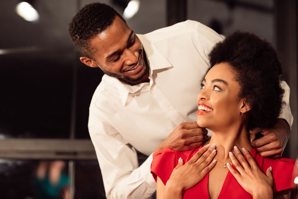 man giving necklace to woman