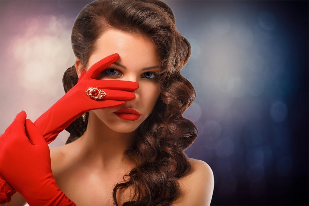 woman with red glove wearing ring with red stone