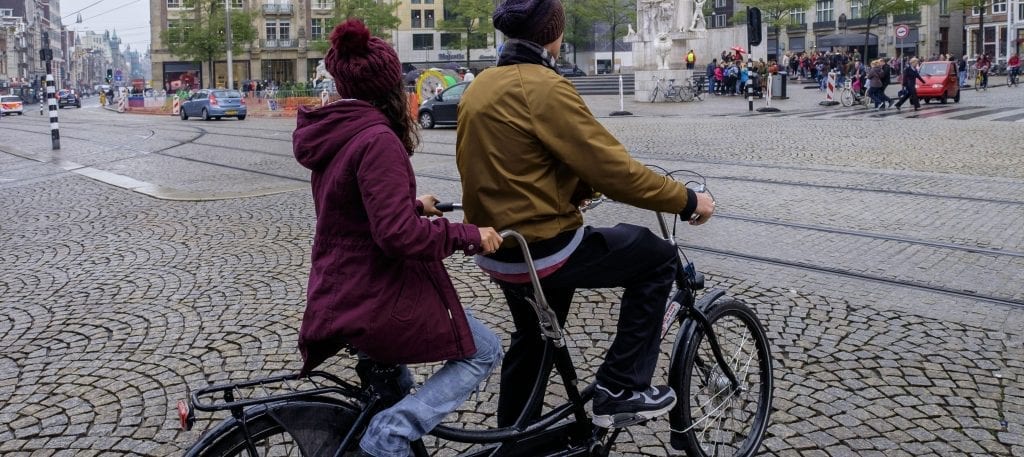 couple cycling in Amsterdam on a tandem bike