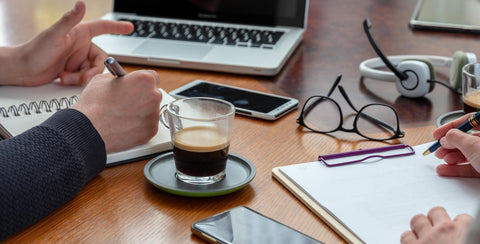 A cup of a shot of espresso on a coaster