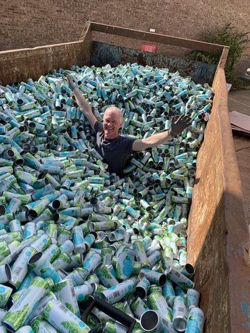 Founder of the Quenched soft drinks company in a skip of recycled cans