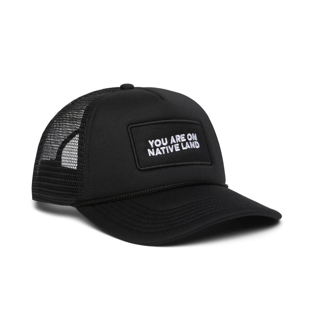 “You Are On Native Land” Trucker Hat in black.