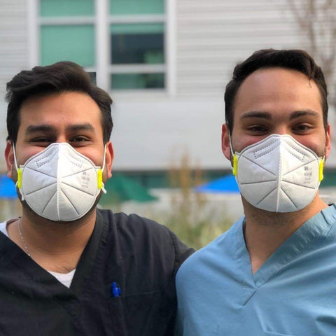 two adult males wearing properly fitted n95 masks outside