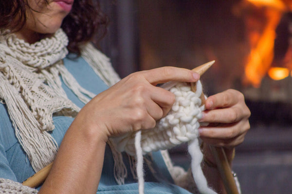 Lady knitting by an open fire