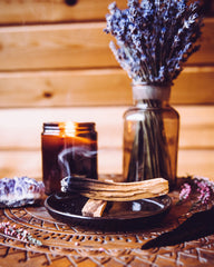 Candle and Palo Santo with a vase of lavender in a wooden room