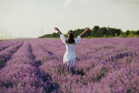 A women with her hands outstretched in a lavender field