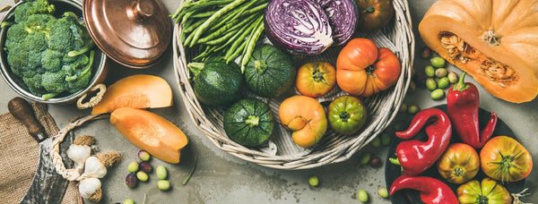 A table laid with bowls of ripe fruit and vegetables in a rainbow of colours