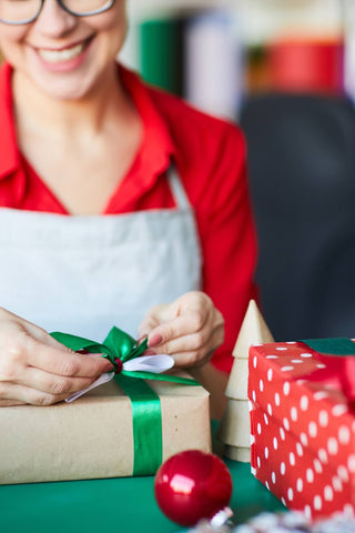 Smiling small business owner wrapping Christmas presents