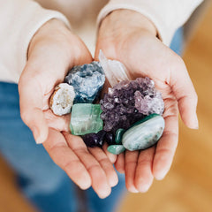 A handful of colourful crystals of different shapes and textures