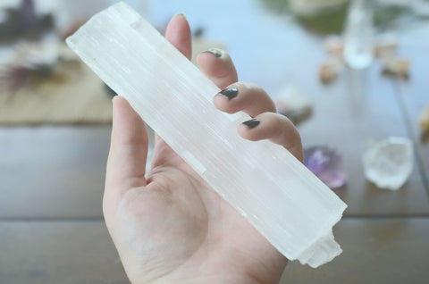 A large bar of white selenite crystal held to cleanse the space