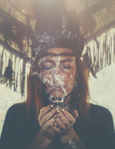 A medicine woman using smoke to cleanse her energy
