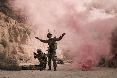 Deux militaires dans de la fumée rose