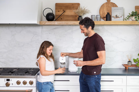 Man pouring girl a cup of filtered water