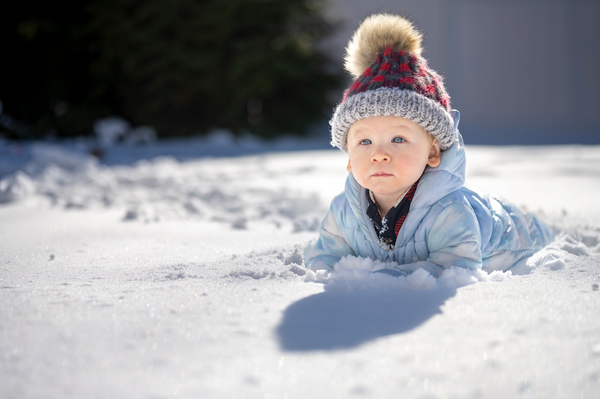 baby playing in snow in winter