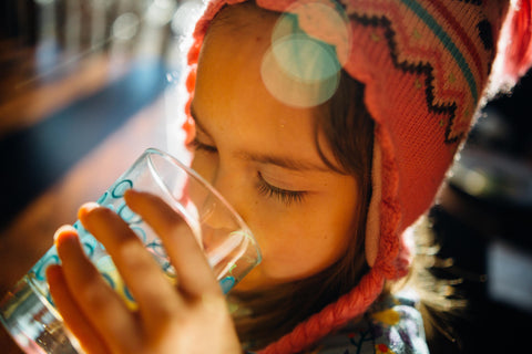 Little girl drinking tap water from a glass