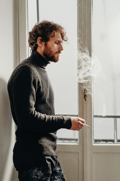 Man smoking a cigarette at home